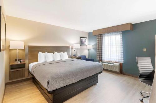 a hotel room with a bed and a chair at Quality Inn Newton at I-80 in Newton