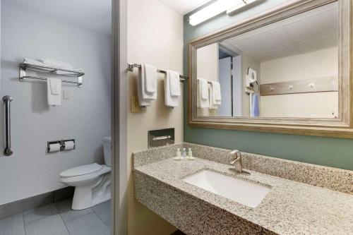 a bathroom with a sink and a toilet and a mirror at Quality Inn Newton at I-80 in Newton