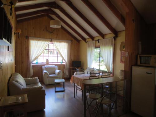 uma sala de estar com um sofá e uma mesa em Cabañas Bordenieve em Valle Las Trancas