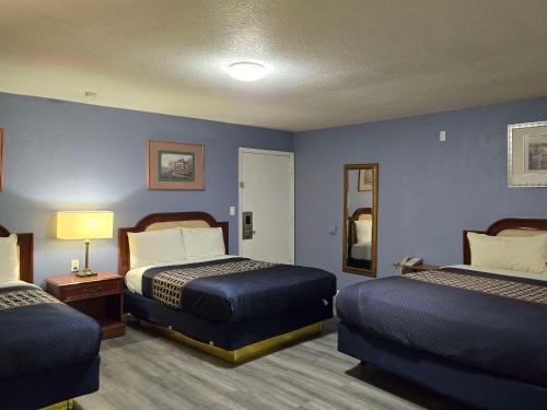 a hotel room with two beds and blue walls at Rodeway Inn & Suites Blythe I-10 in Blythe