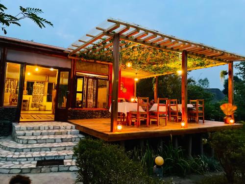 a wooden deck with a table and chairs on it at Wild Tracks Overland Camp in Kasese