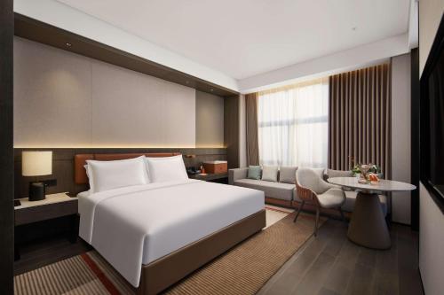 a bedroom with a bed and a living room at Doubletree By Hilton Kaifeng in Kaifeng