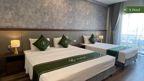 a hotel room with two beds and a window at X Hotel Thái Nguyên in Thái Nguyên