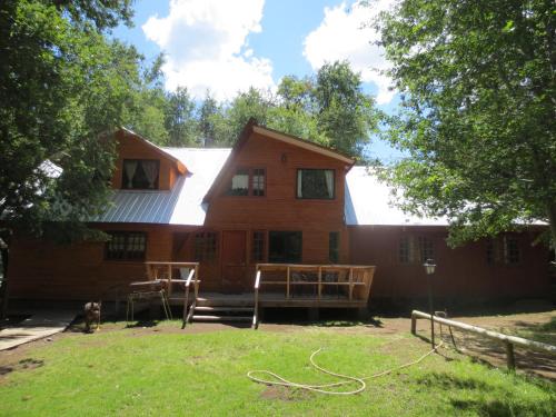 a large wooden house with a white roof at Cabañas Bordenieve in Las Trancas