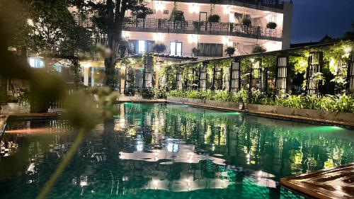 a pool of water in front of a building at night at X Hotel Thái Nguyên in Thái Nguyên