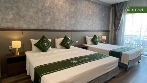 a hotel room with two beds and a window at X Hotel Thái Nguyên in Thái Nguyên