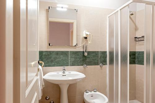 a bathroom with a sink and a toilet and a mirror at The Port Residence in Livorno