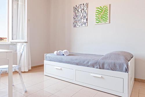 a white bedroom with a bed and a desk at The Port Residence in Livorno
