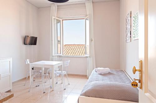 a bedroom with a bed and a table and a window at The Port Residence in Livorno