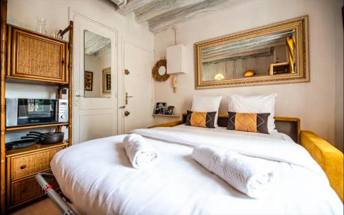 une chambre avec un grand lit blanc et une télévision dans l'établissement Appartement pour 2 personnes, à Paris