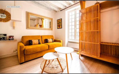 un salon avec un canapé jaune et une table dans l'établissement Appartement pour 2 personnes, à Paris