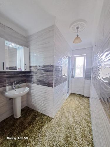 a white bathroom with a sink and a shower at Salda Gölü Çeliköz Apart in Yeşilova