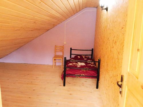 a bedroom with a bed and a chair in a attic at Elos Guesthouse in Iprari