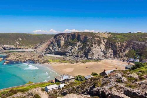 an aerial view of a beach on a cliff at The Cuckoo's Retreat - Luxurious home with private garden & jacuzzi in Kenwyn