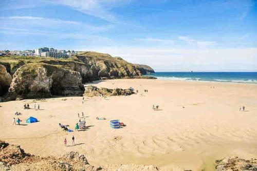 a group of people on a beach near the ocean at The Cuckoo's Retreat - Luxurious home with private garden & jacuzzi in Kenwyn