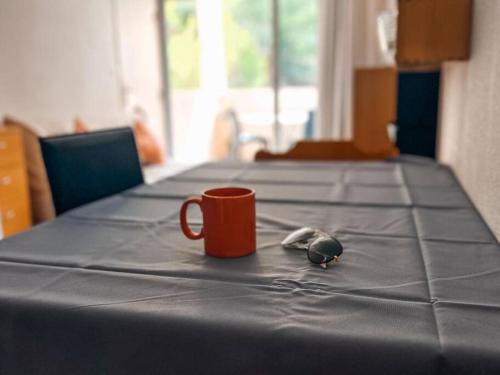 ein Tisch mit einer Kaffeetasse und einer Maus darauf in der Unterkunft Appt T2 4 couchages climatisation piscine in Saint-Joseph