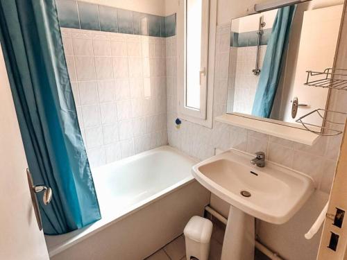 ein Badezimmer mit Badewanne und Waschbecken in der Unterkunft Appt T2 4 couchages climatisation piscine in Saint-Joseph