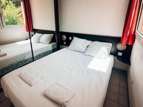 une petite chambre avec deux lits et une fenêtre dans l'établissement Appt T2 4 couchages climatisation piscine, à Saint-Joseph