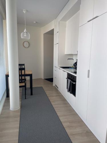 a kitchen with white cabinets and a dining room at Snowflake Suites VII in Rovaniemi