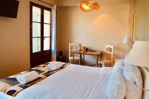 a bedroom with a bed and a table and a window at Domaine Gaogaia in Aix-en-Provence