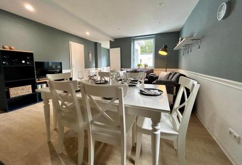 a dining room with a white table and chairs at Smilla in Bad Segeberg