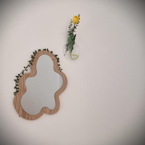 a guitar shaped mirror and a vase with a flower at Apartments in Graz in Graz