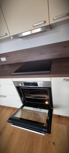 a microwave oven in a kitchen with wooden floors at Apartments in Graz in Graz