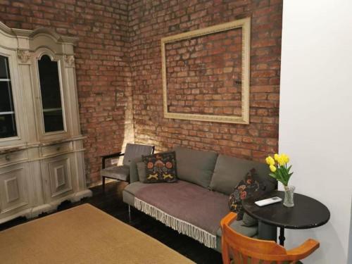 a living room with a couch and a brick wall at Golden Age Hollywood PROMO PRICE! in Vračar (historical)