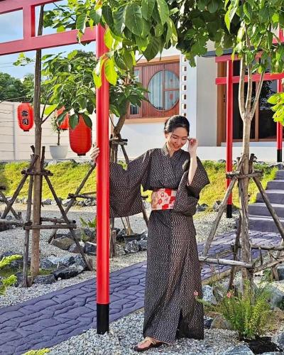 a woman standing next to a red pole at Taka Onzen in Ban Khao Ket