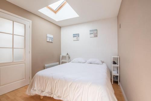 - une chambre blanche avec un lit et une lucarne dans l'établissement Maison mitoyenne- 4 pers - Centre historique de Pornic, à Pornic