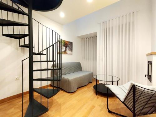 a living room with a spiral staircase and a couch at Marelia Urban in Thessaloniki