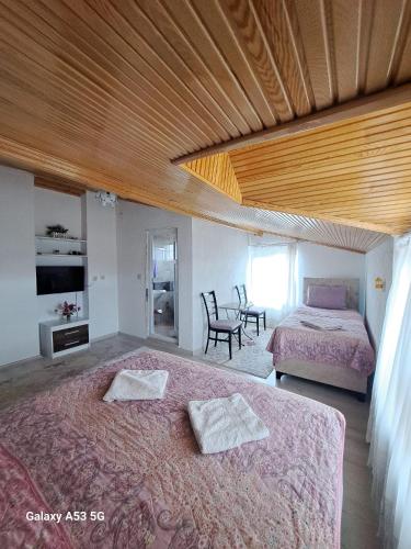 a bedroom with two beds and a table and chairs at Salda Gölü Çeliköz Apart in Yeşilova
