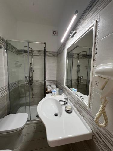 a white bathroom with a sink and a shower at Le Tre Rose in Maratea