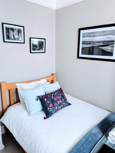 a bedroom with a bed with white sheets and pillows at Alexander Lodge in Bournemouth