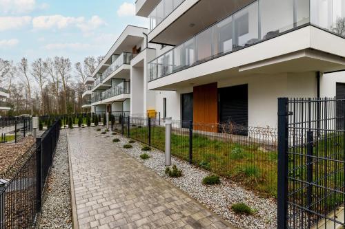 a building with a fence next to a sidewalk at Modern Apartment With Private Garden Międzywodzie by Renters Prestige in Międzywodzie