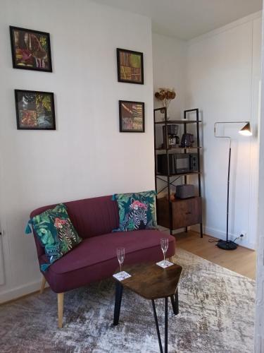 un salon avec un canapé violet et une table dans l'établissement Appartement au cœur du patrimoine sézannais, à Sézanne