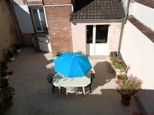 a blue umbrella sitting on a table in a patio at Appartement au cœur du patrimoine sézannais in Sézanne