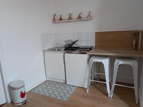 a kitchen with a table and a sink and stool at Appartement au cœur du patrimoine sézannais in Sézanne
