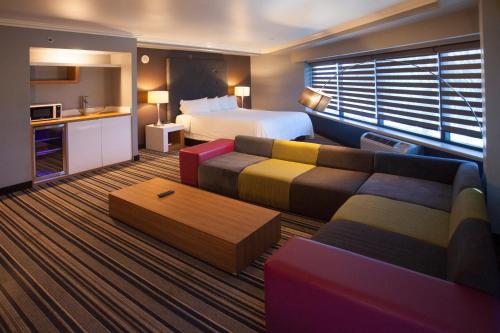 a hotel room with a bed and a couch at Hotel Huntington Beach in Huntington Beach