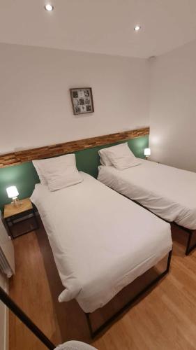 deux lits côte à côte dans une pièce dans l'établissement L'Escapade de Watten, à Watten