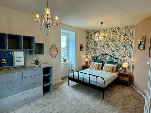 - une chambre avec un lit, une commode et un lustre dans l'établissement Villa Gabrielle De La Mer avec Piscine Privée, à Étables