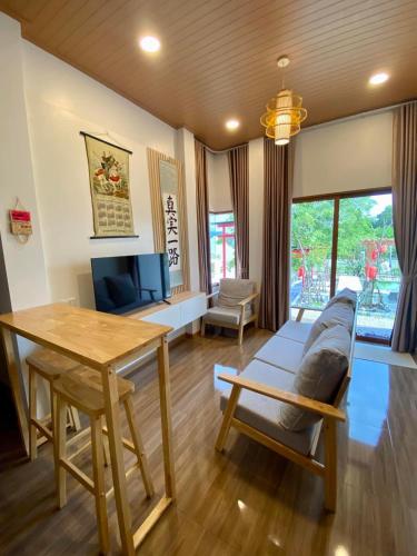 a living room with a couch and a table at Taka Onzen in Ban Khao Ket