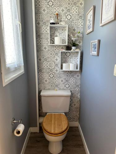 La salle de bains est pourvue de toilettes et d'un siège en bois. dans l'établissement Villa Gabrielle De La Mer avec Piscine Privée, à Étables