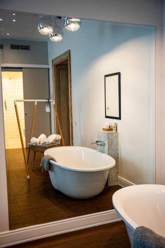 a bathroom with a large tub and a mirror at Tiszavirág Szeged in Szeged