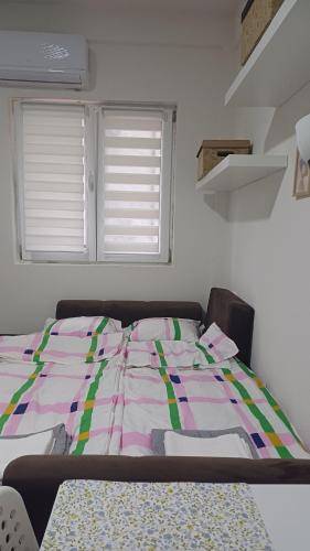 a bedroom with a bed with a colorful comforter at Studio Mili in Malovići