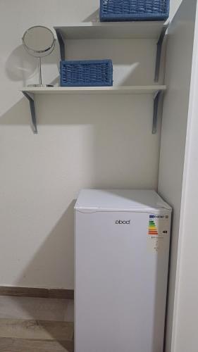 a white refrigerator in a room with shelves at Studio Mili in Malovići
