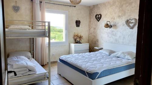 une chambre avec deux lits superposés et une fenêtre dans l'établissement La Villa Ganesh : maison de campagne dans le Gard !, à Saint-André-dʼOlérargues