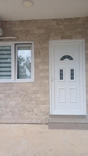 a white door and windows on a brick wall at Studio Mili in Malovići
