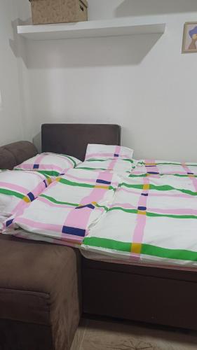 a bed with a colorful comforter and pillows on it at Studio Mili in Malovići
