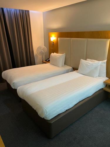 two beds sitting next to each other in a hotel room at Holiday Inn Sittingbourne by IHG in Sittingbourne